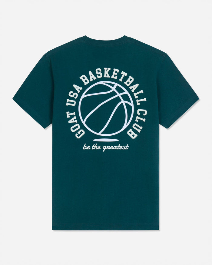 A dark teal green short-sleeve t-shirt with a white graphic print on the back featuring a basketball and the text 'GOAT USA BASKETBALL CLUB' and 'be the greatest'.