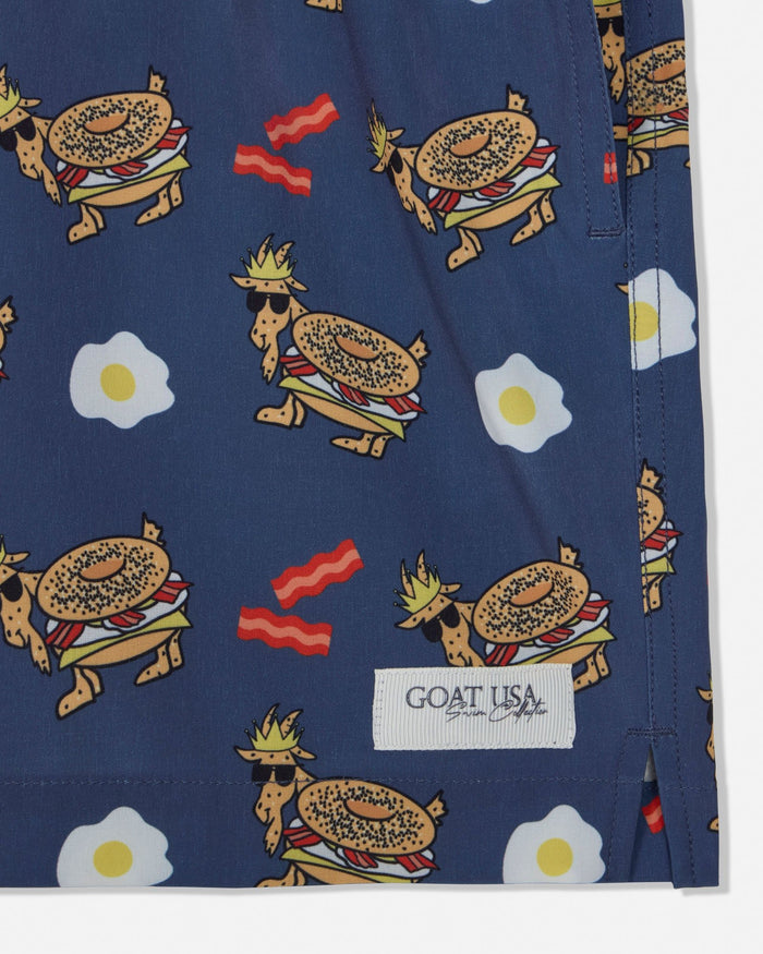 Navy shorts with a colorful pattern of bagels, eggs, and bacon on a white background.