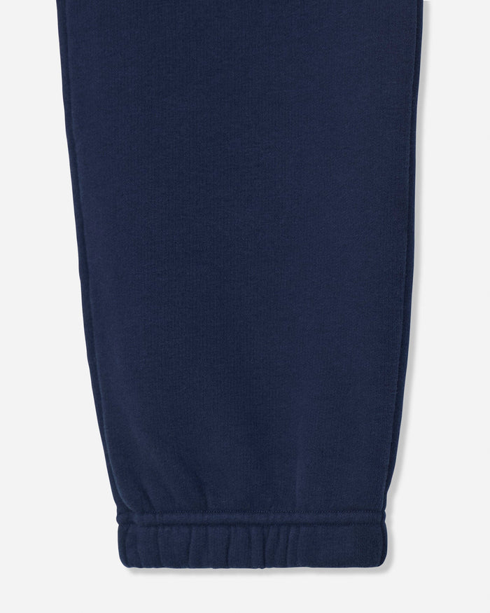 Close-up of a navy blue sweatpants leg showing the ribbed elastic cuff on a light gray background.#color_navy-blazer