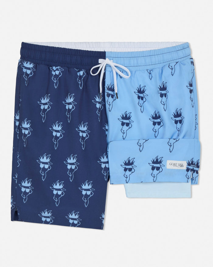Pair of navy and light blue swim shorts with goat wearing sunglasses pattern on a white background