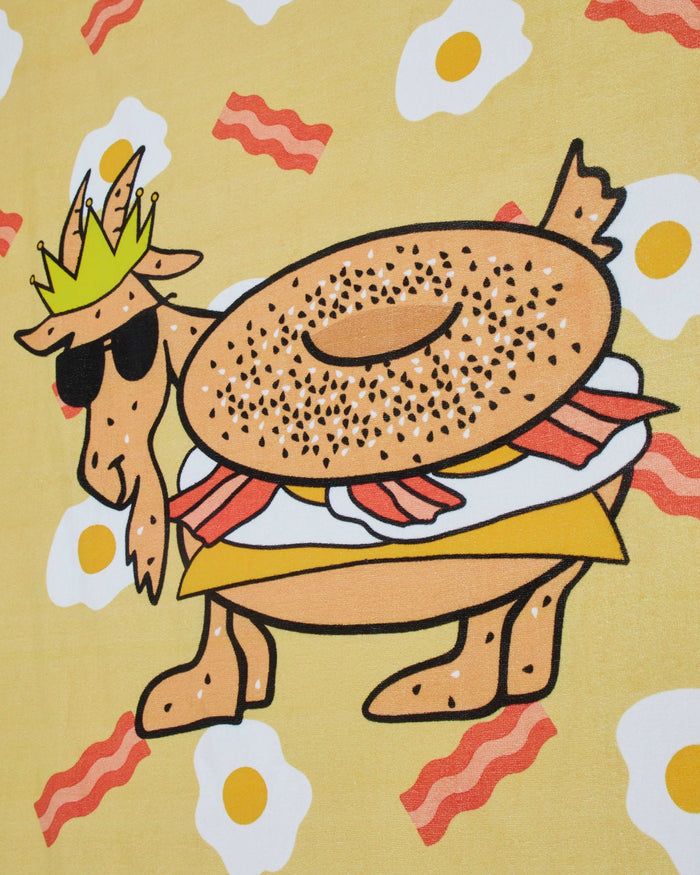 Close-up of beach towel with bacon, egg and cheese pattern plus bacon egg and cheese goat