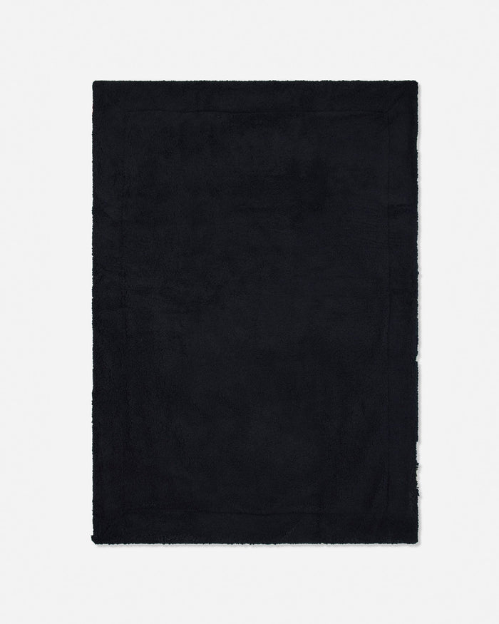 A solid black rectangular blanket with frayed edges, shown flat against a light gray background.