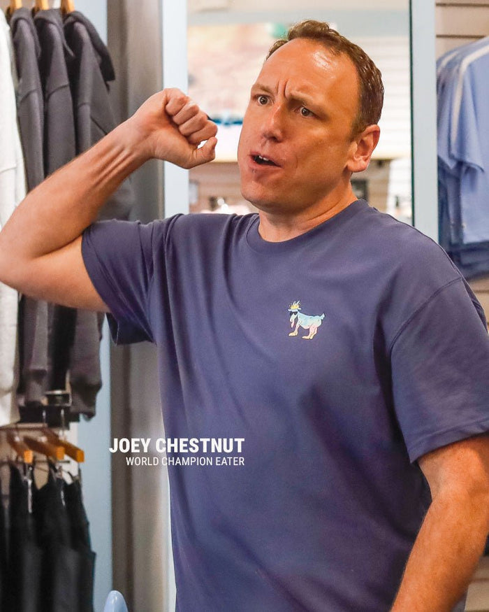 Joey Chestnut pumping his fist and text that reads "Joey Chestnut World Champion Eater"