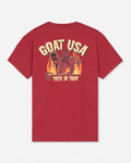 A red short-sleeve t-shirt shown from the back, featuring a large graphic print with the text 'GOAT USA' and 'TRICK OR TREAT' in cream and yellow, surrounding an illustration of a goat in flames.