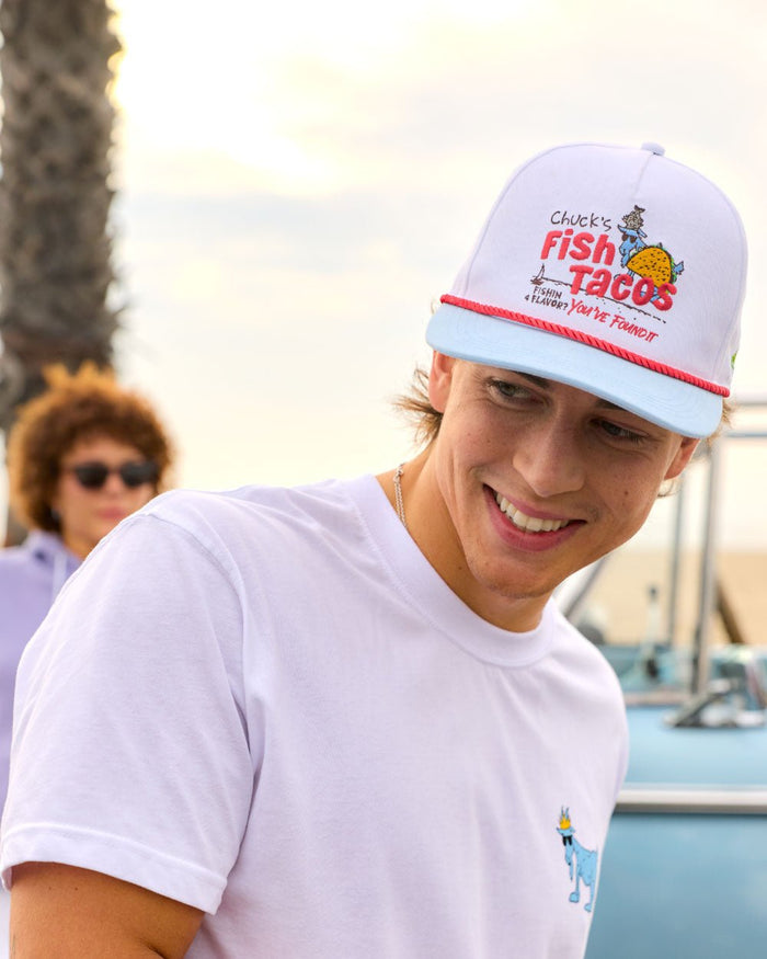 Person wearing a 'Chuck's Fish Tacos' cap with a blurred background