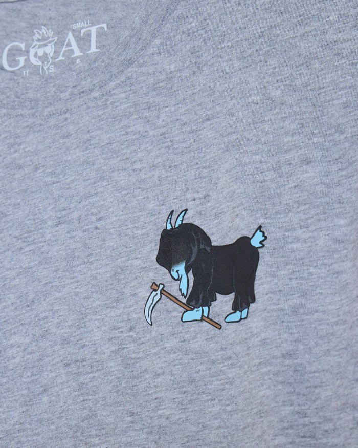 Close-up of a heather gray t-shirt featuring a graphic of a blue goat holding a scythe, with a white 'GOAT' brand logo printed in the upper left corner.