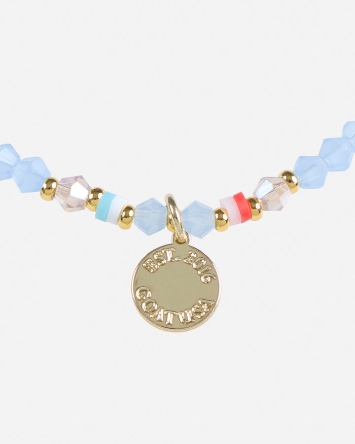 Bracelet with colorful beads and a gold charm on a white background