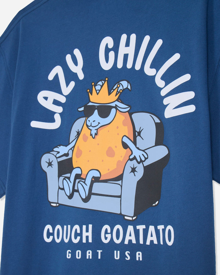Close-up of a blue graphic T-shirt featuring a cartoon goat sitting in a couch with the text 'LAZY CHILLIN' above and 'COUCH GOATATO GOAT USA' below.