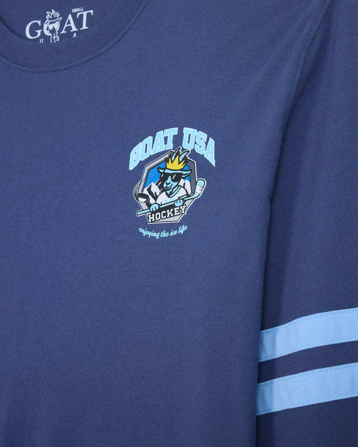 Close-up of a navy blue long-sleeve t-shirt with a light blue and white 'GOAT USA Ice Hockey' graphic on the chest and two light blue stripes on the sleeve.