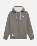 A taupe-brown full-zip hoodie with a cream sherpa-lined hood, featuring a small white graphic on the left chest, a circular patch on the lower left front pocket, and a small graphic on the right sleeve cuff.#color_smokey-olive