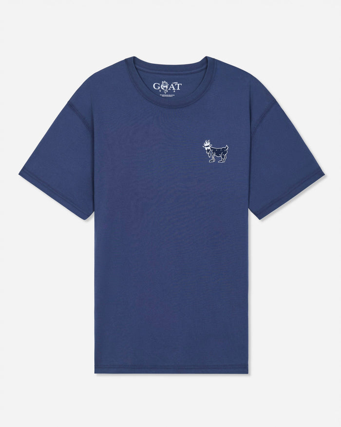 A blue short-sleeve t-shirt with a small white goat logo on the left chest and a white 'GOAT' brand print inside the collar, shown on a light gray background.#color_navy