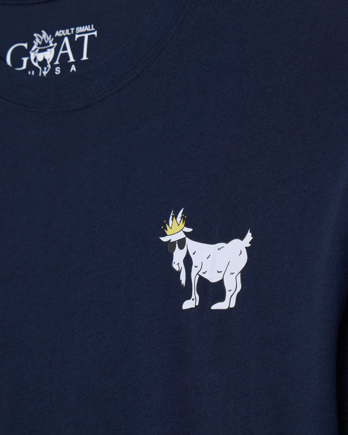 Close-up of a navy blue t-shirt featuring a white goat graphic with a gold crown on the chest and a white 'GOAT' brand logo printed inside the collar.#color_navy-blazer