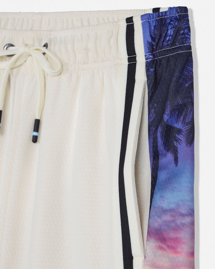 Beige pants with a colorful palm tree pattern on a white background