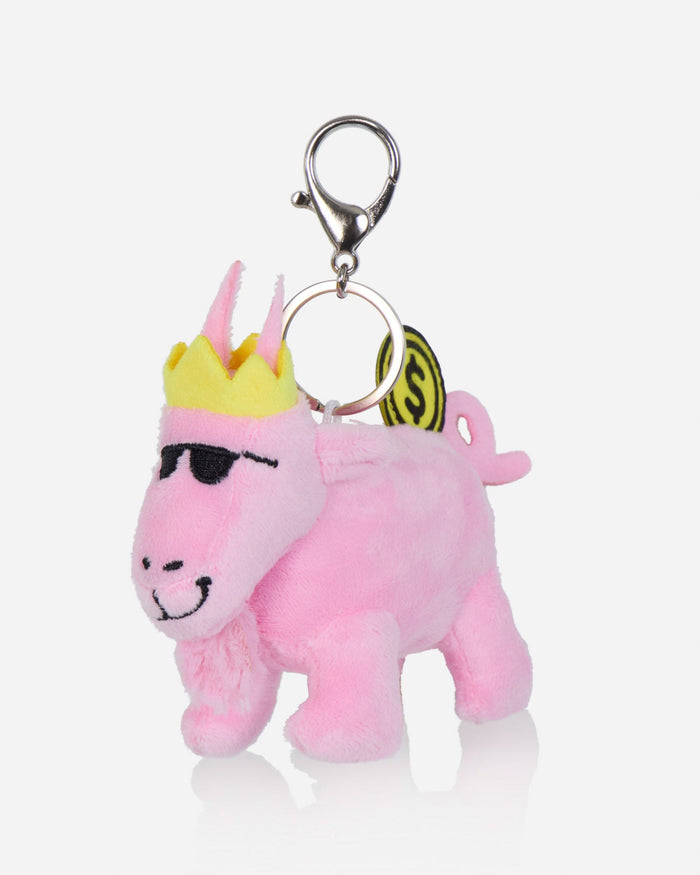 A pink plush bag charm shaped like a stylized animal character with a yellow crown, black sunglasses, and a metal clasp on a light gray background.