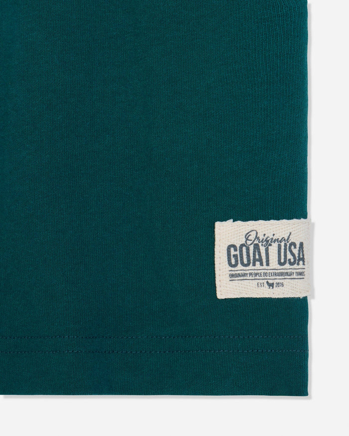 Close-up of stitched patch on sage t-shirt