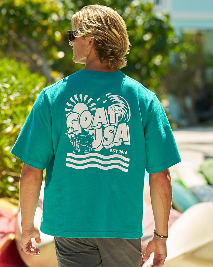 Man walking away from the camera in a teal blue t-shirt