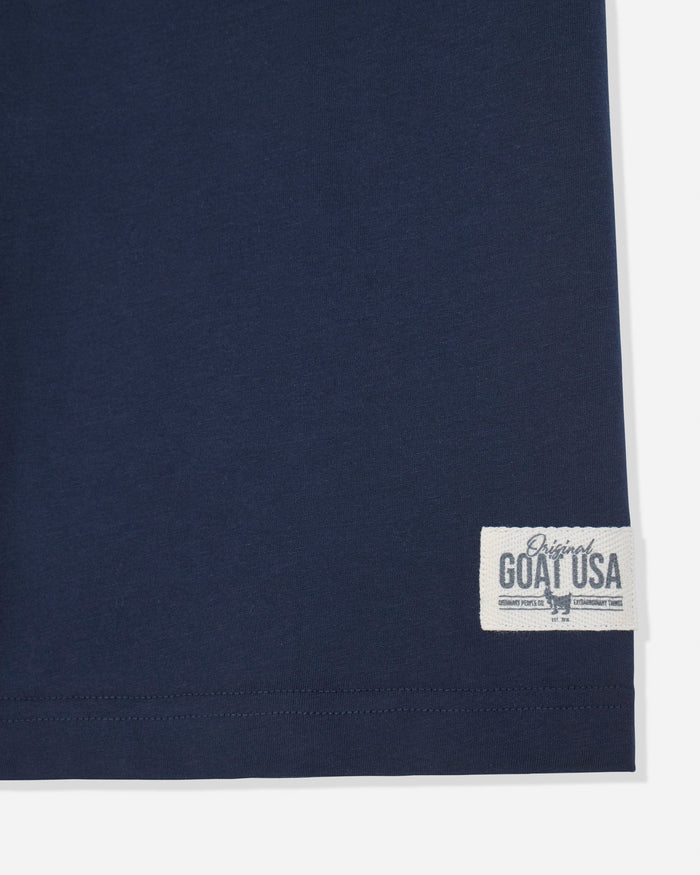 Close-up of a navy blue garment corner with a white woven label reading 'Original GOAT USA' on a light background.