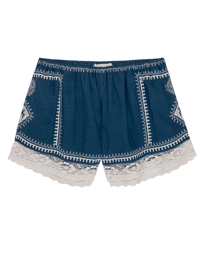 The Sparrow Short by THE GREAT. PF26 features a mineral blue hue with white embroidery and scalloped white lace trim—perfect women’s shorts for casual summer days.