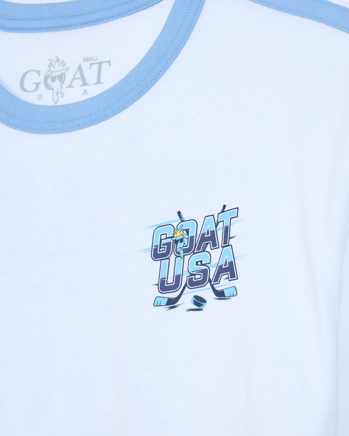 Close-up of a white T-shirt with light blue trim at the collar and a blue and white 'GOAT USA' graphic printed on the chest.
