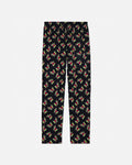 Black pajama pants with colorful pattern on a light gray background