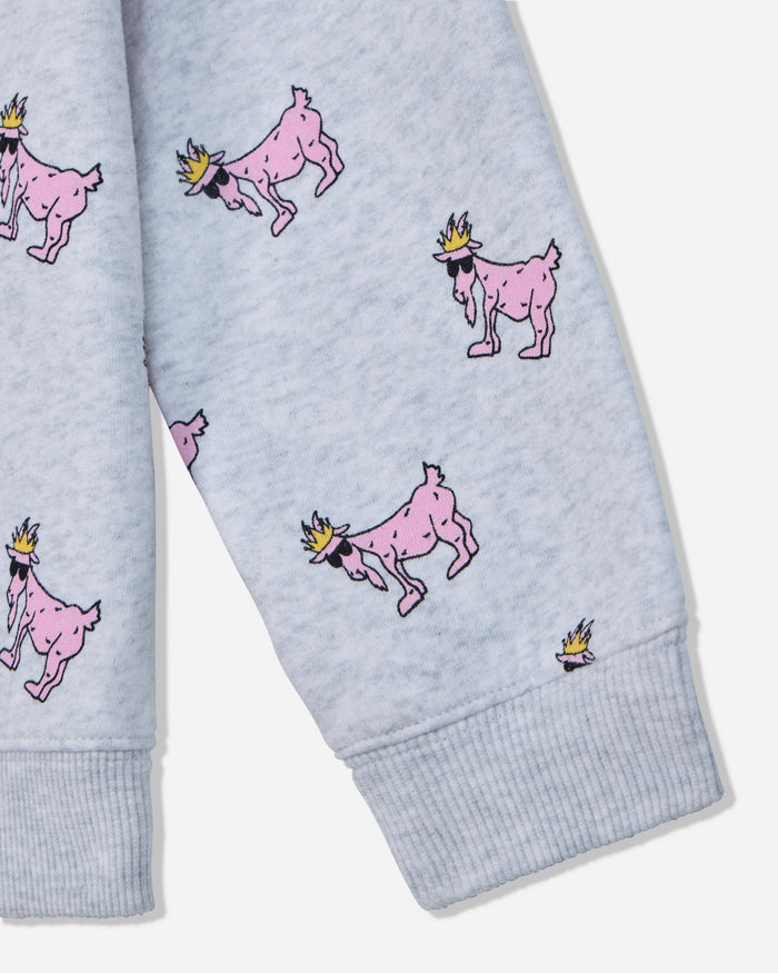 Close-up of a light heather gray fabric garment with an allover print of pink cartoon goats wearing small yellow crowns, shown on a sleeve with ribbed cuffs.#color_pale-gray-heather