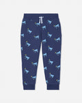 A pair of navy blue jogger pants featuring an all-over print of cartoon cows in light blue and yellow, with a white drawstring at the elastic waistband.#color_navy