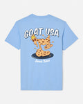 A light blue short-sleeve t-shirt shown from the back, featuring a cartoon graphic of a goat wearing a crown and standing on chocolate chip cookies, with the text 'GOAT USA' and 'Sweet Bites'.