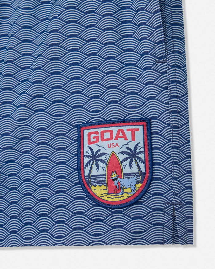 Blue bathing suit with wave pattern and 'GOAT USA' logo on a white background